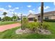 Lovely single-story home with a manicured lawn and garden beds, featuring a vibrant red driveway at 2015 W Del Webb Blvd, Sun City Center, FL 33573