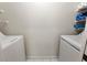 A well-lit laundry room with two white appliances and shelving at 2015 W Del Webb Blvd, Sun City Center, FL 33573