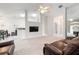 Inviting living room with a ceiling fan, neutral carpeting, and an open layout, perfect for relaxation at 2015 W Del Webb Blvd, Sun City Center, FL 33573