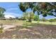 View of the spacious backyard featuring a fire pit, mature trees, and a golf course in the distance at 2219 Summit View Dr, Valrico, FL 33596