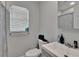Clean, compact bathroom featuring a toilet, sink, mirror, and window with blinds at 2219 Summit View Dr, Valrico, FL 33596