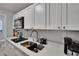 Well-lit kitchen with stainless steel sink, white countertops, and sleek white cabinets at 2219 Summit View Dr, Valrico, FL 33596
