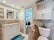 Bright bathroom featuring a vanity, toilet, and tiled flooring at 230 Medallion Blvd # G, Madeira Beach, FL 33708