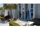 Charming condo exterior with well-maintained walkway, tropical landscaping, grill and seating area at 230 Medallion Blvd # G, Madeira Beach, FL 33708
