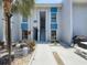 Condo exterior with blue accents, a well-maintained walkway, palm trees, and a grill area for outdoor enjoyment at 230 Medallion Blvd # G, Madeira Beach, FL 33708