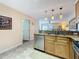 Cozy kitchen with granite countertops, stainless steel appliances, tile flooring and pendant lights at 230 Medallion Blvd # G, Madeira Beach, FL 33708