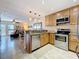 Spacious kitchen featuring granite countertops, stainless steel appliances, and open access to the living room at 230 Medallion Blvd # G, Madeira Beach, FL 33708