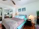 Relaxing bedroom with hardwood floors, ceiling fan, closet with mirrored doors, and bright decor at 230 Medallion Blvd # G, Madeira Beach, FL 33708