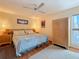 Bedroom with wood floors, ceiling fan, comfortable bed, wardrobe, and natural light at 230 Medallion Blvd # G, Madeira Beach, FL 33708