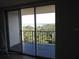 Balcony overlooking trees and water, accessible through sliding glass doors at 2699 Seville Blvd # 802, Clearwater, FL 33764