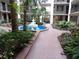 Beautiful courtyard featuring a striking blue fountain, lush tropical landscaping, and brick-paved pathways at 2699 Seville Blvd # 802, Clearwater, FL 33764