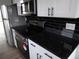 Updated kitchen featuring stainless steel appliances, black granite countertops, and white cabinets at 2699 Seville Blvd # 802, Clearwater, FL 33764
