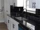 Kitchen area with black granite countertops, stainless steel sink, and modern faucet at 2699 Seville Blvd # 802, Clearwater, FL 33764