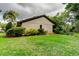 Green backyard featuring a well-kept lawn and lush tropical landscaping at 2913 Fig Ct, Palm Harbor, FL 34684