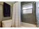 The renovated bathroom has a shower with gray tile and a window at 2913 Fig Ct, Palm Harbor, FL 34684