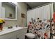 This cheerful bathroom features a shower with a floral curtain, a white vanity, and tiled walls at 2913 Fig Ct, Palm Harbor, FL 34684