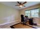 Bright bedroom features a ceiling fan, a desk with a computer, and a large window providing natural light at 2913 Fig Ct, Palm Harbor, FL 34684