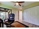 Bright home office offers closet, sliding glass doors to deck, desk and ceiling fan at 2913 Fig Ct, Palm Harbor, FL 34684