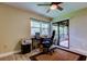 Well lit home office includes view of deck through sliding glass door, desk, computer and ceiling fan at 2913 Fig Ct, Palm Harbor, FL 34684