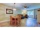 Inviting dining area with a modern light fixture, wood-style flooring, and a view into the living room at 2913 Fig Ct, Palm Harbor, FL 34684