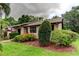 Inviting exterior with lush landscaping, colorful bromeliads, and a well-maintained lawn at 2913 Fig Ct, Palm Harbor, FL 34684