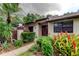 Charming building exterior with beautiful landscaping, complemented by colorful bromeliads at 2913 Fig Ct, Palm Harbor, FL 34684