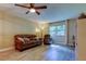 Spacious living room featuring a ceiling fan, wood-look flooring, and ample natural light from a large window at 2913 Fig Ct, Palm Harbor, FL 34684