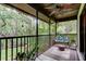 Screened patio with ceiling fan and outdoor seating overlooks lush greenery creating a relaxing space at 2913 Fig Ct, Palm Harbor, FL 34684