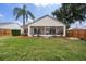 A spacious backyard with healthy lawn, a palm tree, and a screened lanai at 29713 Bright Ray Pl, Wesley Chapel, FL 33543