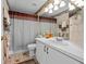 Bathroom with laminate floors, single sink vanity, framed mirror and enclosed shower at 29713 Bright Ray Pl, Wesley Chapel, FL 33543