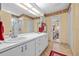 Bathroom with dual sinks, granite countertops, and an open view into the bedroom at 29713 Bright Ray Pl, Wesley Chapel, FL 33543