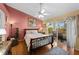 Cozy bedroom with wood floors, a ceiling fan, and lanai access with natural light at 29713 Bright Ray Pl, Wesley Chapel, FL 33543