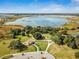Scenic aerial view of lake with surrounding park, trees and community amenities at 32231 Conchshell Sail St, Wesley Chapel, FL 33545