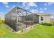 Landscaped backyard features a screened patio and a lush lawn at 32231 Conchshell Sail St, Wesley Chapel, FL 33545