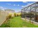 Backyard featuring green grass, plants, and a screened patio, perfect for outdoor enjoyment at 32231 Conchshell Sail St, Wesley Chapel, FL 33545