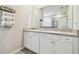 Bathroom with double vanity, white cabinets, granite countertop, and large mirror at 32231 Conchshell Sail St, Wesley Chapel, FL 33545
