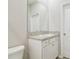 Bathroom features white cabinet vanity with granite countertop and large mirror at 32231 Conchshell Sail St, Wesley Chapel, FL 33545