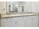 Bathroom with double vanity, white cabinets, granite countertop, and large mirror at 32231 Conchshell Sail St, Wesley Chapel, FL 33545