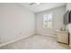 Carpeted room with shuttered window and TV setup on top of a wooden drawer at 32231 Conchshell Sail St, Wesley Chapel, FL 33545