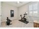Bedroom with workout equipment including a Peloton bike, mirror and bench with weights at 32231 Conchshell Sail St, Wesley Chapel, FL 33545