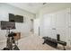 Carpeted exercise room features a stationary bike, TV, and workout bench at 32231 Conchshell Sail St, Wesley Chapel, FL 33545