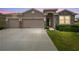 Charming home with a three-car garage, stone accents, well-manicured lawn, and welcoming curb appeal at 32231 Conchshell Sail St, Wesley Chapel, FL 33545