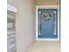 Stylish blue front door with decorative wreath and sidelights, welcoming visitors at 32231 Conchshell Sail St, Wesley Chapel, FL 33545