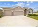 Charming home with a three car garage and stone facade and a well manicured lawn at 32231 Conchshell Sail St, Wesley Chapel, FL 33545