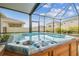Enclosed patio showcases a blue hot tub with a wooden base and overhead screen at 32231 Conchshell Sail St, Wesley Chapel, FL 33545