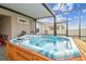 Hot tub with wooden base and screens on a brick-paved patio at 32231 Conchshell Sail St, Wesley Chapel, FL 33545