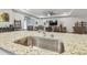 Spacious kitchen island with granite countertop, stainless steel sink, and bar seating, perfect for entertaining at 32231 Conchshell Sail St, Wesley Chapel, FL 33545