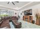 Comfortable living room with leather seating, a ceiling fan, and a fireplace at 32231 Conchshell Sail St, Wesley Chapel, FL 33545