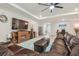 Spacious living room featuring a fireplace, ceiling fan, and comfortable brown leather seating at 32231 Conchshell Sail St, Wesley Chapel, FL 33545