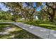 Scenic park walkway through green space with mature trees, providing a peaceful outdoor experience at 32231 Conchshell Sail St, Wesley Chapel, FL 33545